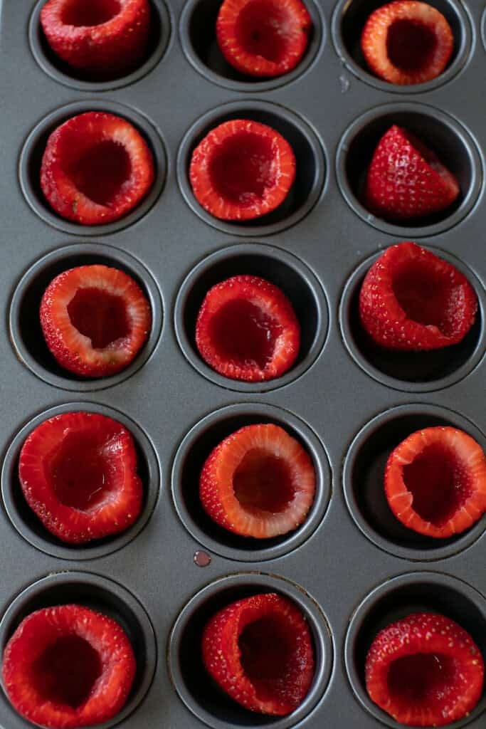 Fresh strawberries in a muffin tin.
