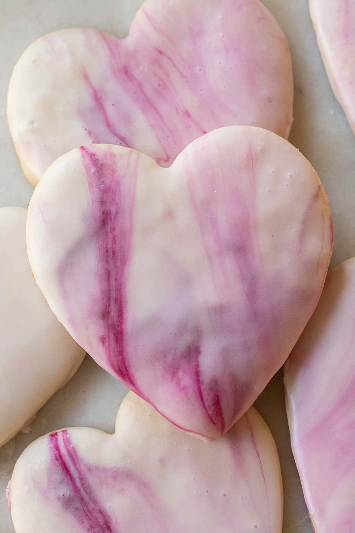 Heart shaped sugar cookie with marble swirl icing.