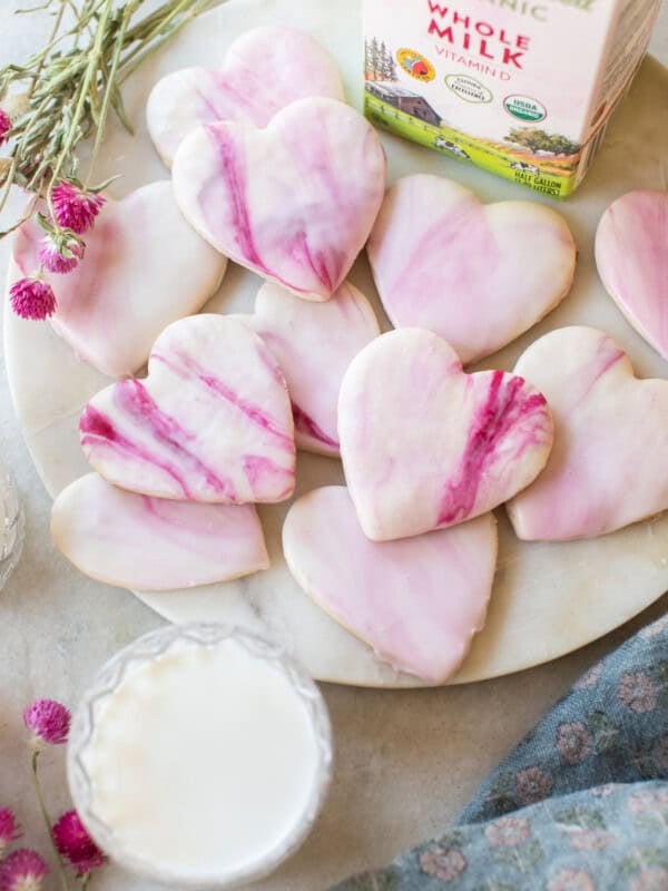 Decorative pink marble heart cookies on a white platter for romantic treats and Valentine's Day desserts.