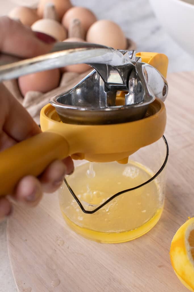 Squeezing fresh lemon juice for lemon olive oil cake recipe.