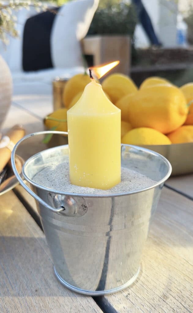 candles in sand-filled buckets for outdoor party lighting.