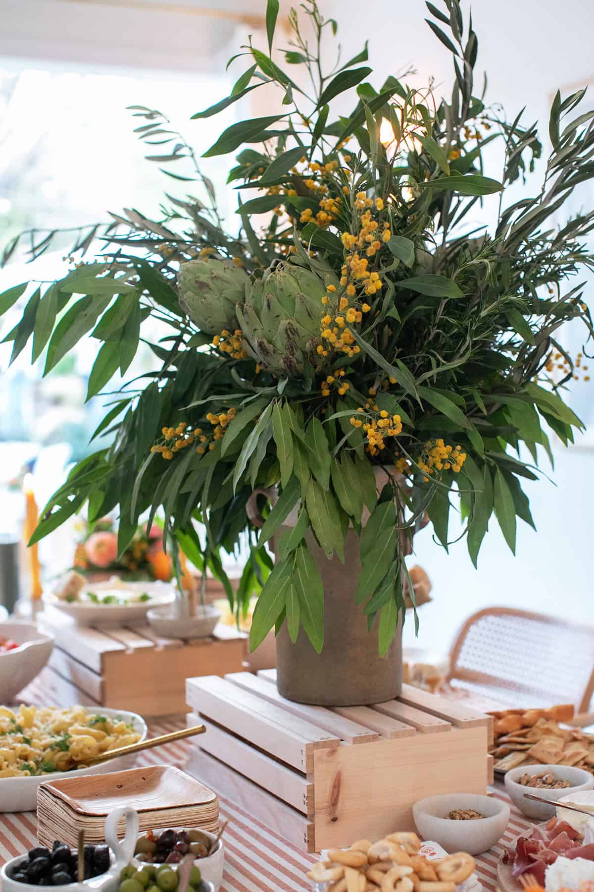 Italian Aperitivo Party flowers on a table filled with appetizers.