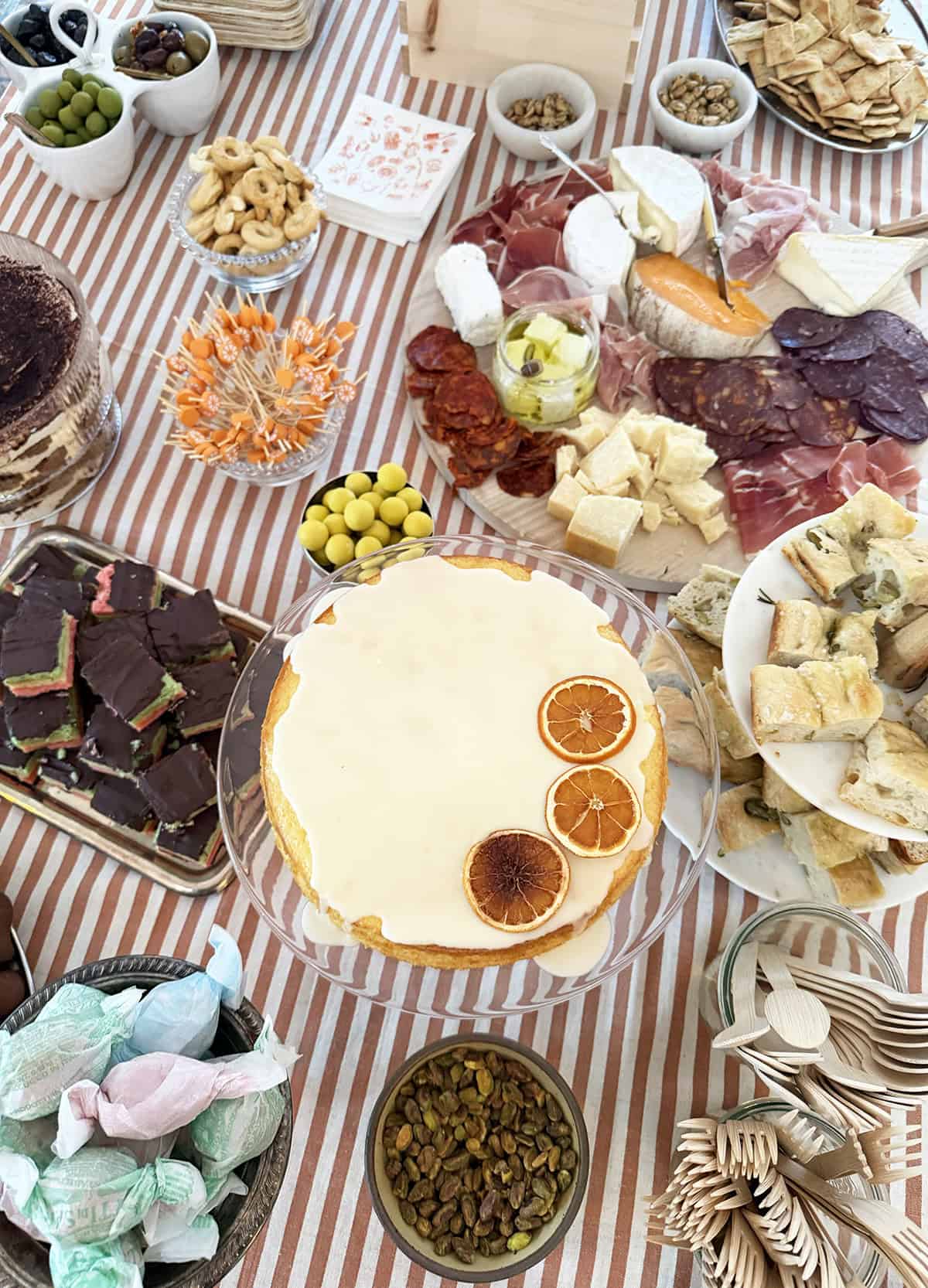 A table filled with Italian appetizers, desserts and party decor.