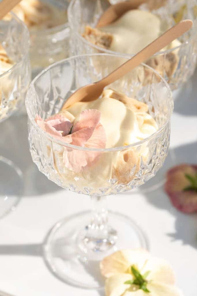 Creamy banana pudding in a glass with edible flowers.