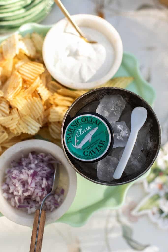 Caviar with potato chips, sour cream, and onions.