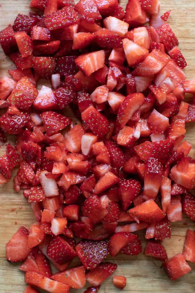 Fresh chopped strawberries with a fork in a small bowl.