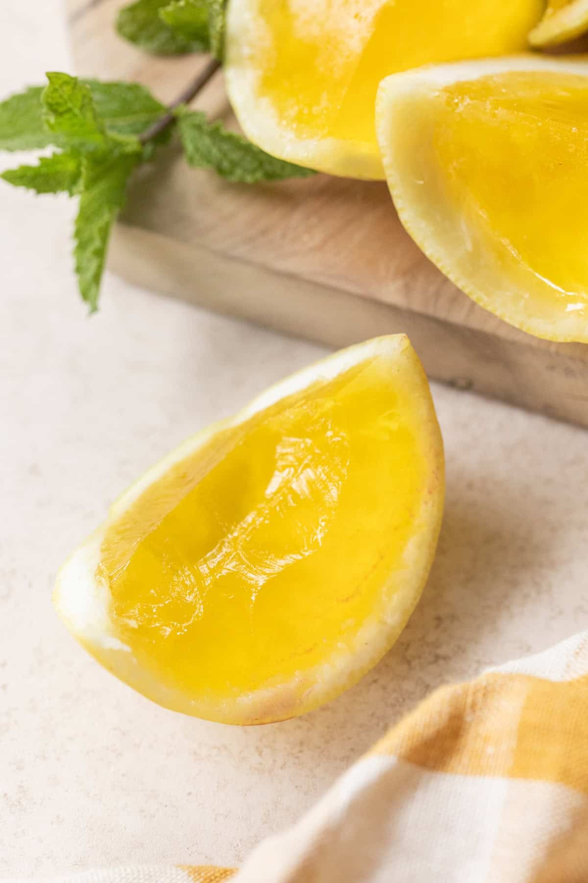 Slicing set Hugo spritz jello shots in citrus cups into wedges with a sharp knife.
