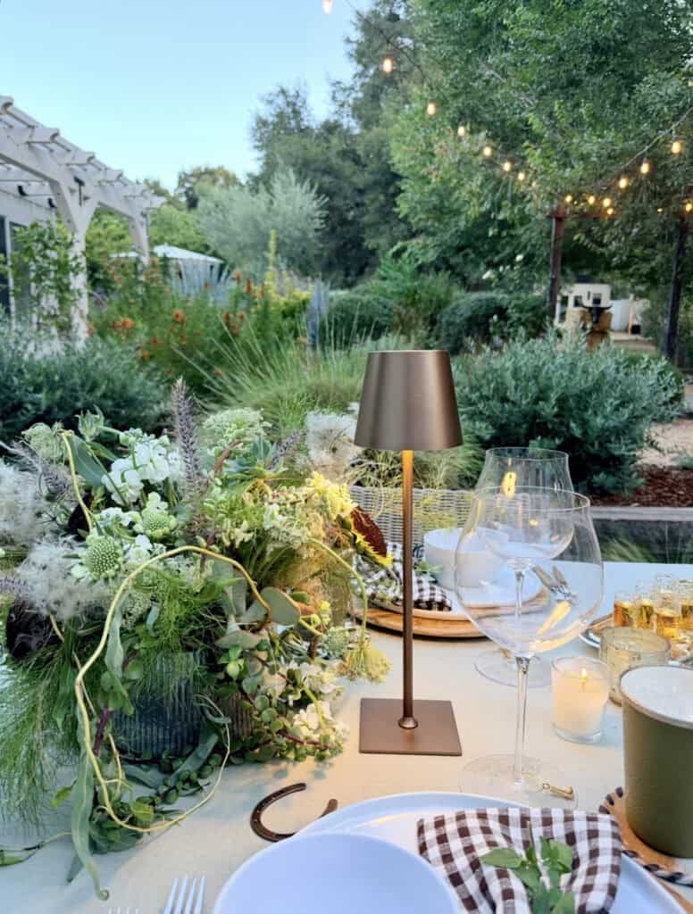 Rodeo dinner party, glowing lantern and flowers on a table setting.