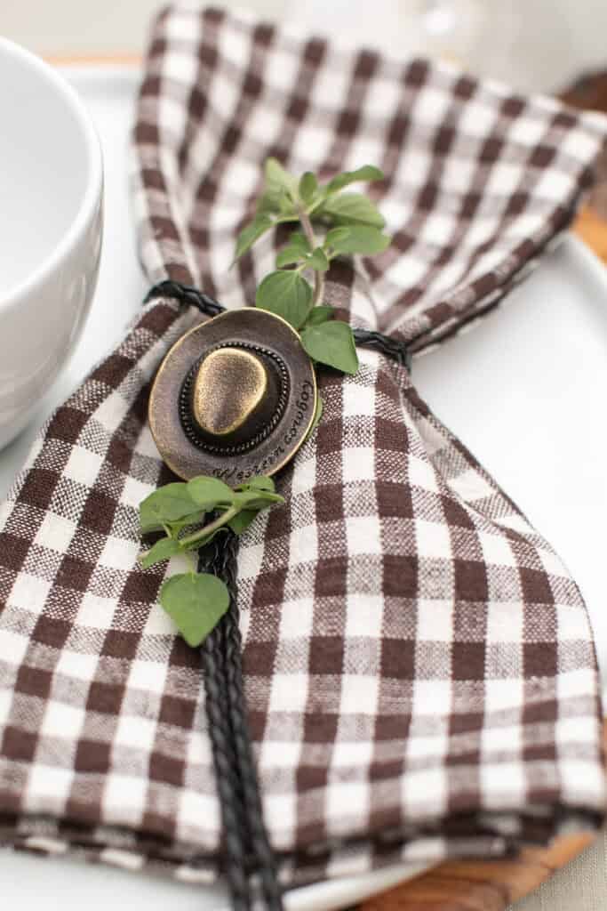 Cowboy hat napkin ties around a checkered napkin.