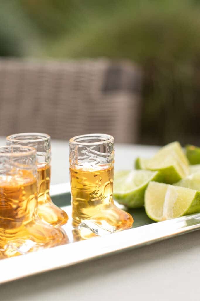 Glass cowboy boot shot glass with limes.