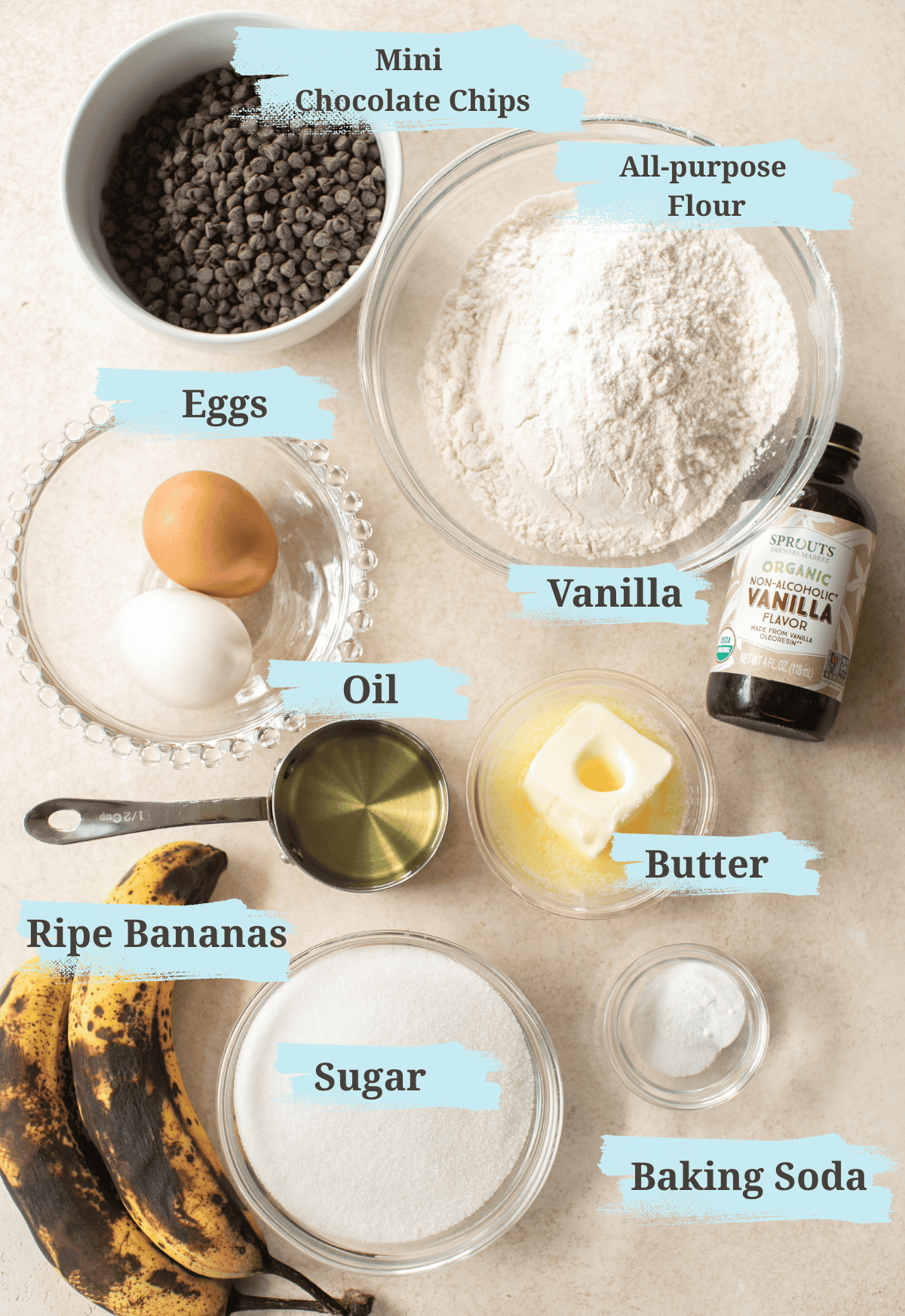 Ingredients for banana chocolate chip muffins including ripe bananas, flour, eggs, butter, and chocolate chips.