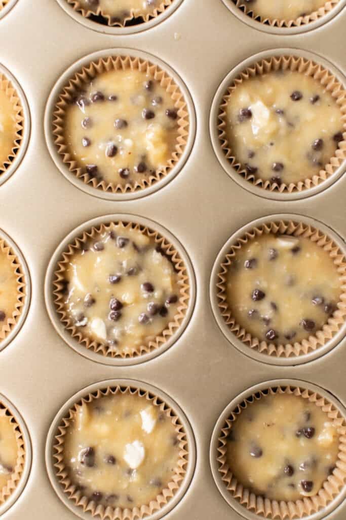 Banana chocolate chip muffin batter divided into a lined muffin pan